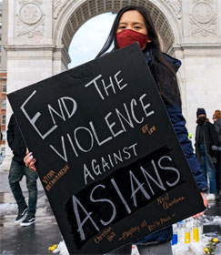 Woman holding sign, "End the violence against Asians"