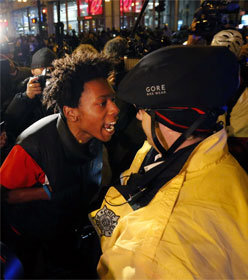 Black protester yelling at white cop, neither wearing a mask