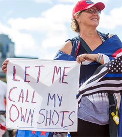 Woman holding sign, "Let me call my own shots"