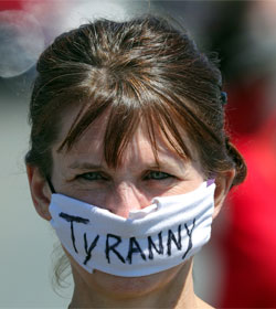 Woman wearing mask that says "Tyranny"