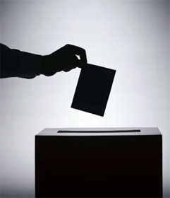 Hand dropping ballot into box