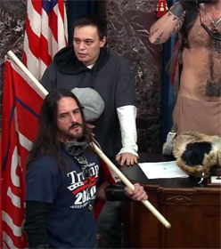 Paul Hodgins, holding flag, and Jacob Chansley, partially shown