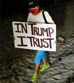 Woman holding "In Trump I Trust" sign