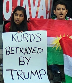 Girl holding sign, "Kurds betrayed by Trump"