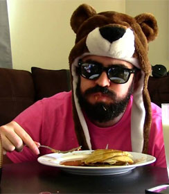 Man in dark glasses eating pancakes