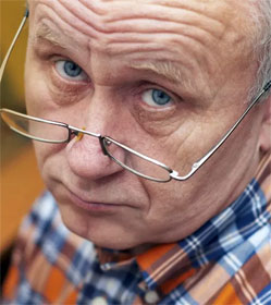 Skeptical man looking over his glasses