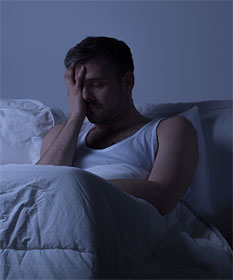 Man trying to wake up in the dark