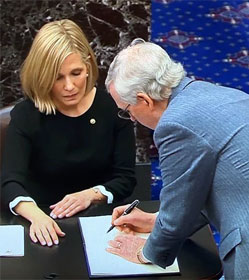 Mitch McConnell signs oath book after swearing to do "impartial justice" at Senate Trump impeachment trial