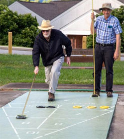 Two men playing shuffleboard