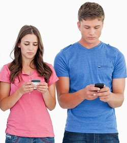 Young man and woman lloking down at smartphones