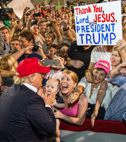 Donald Trump facing crowd including woman with sign, "Thank you Lord Jesus for President Trump"
