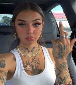 Tattoed woman extending middle finger